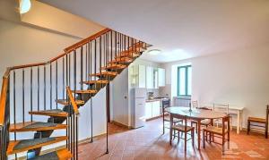 Zimmer mit einer Treppe, einem Tisch und einer Küche in der Unterkunft il sentiero del riccio in Sicignano degli Alburni