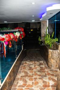 a lobby with a bar with flowers and plants at Hotel Bacatá in Bucaramanga