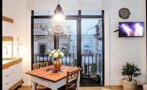 Un comedor con una mesa y un gran ventanal. en Loft Boho en el Centro Histórico Imperdible, en Ciudad de México