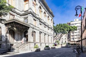 un gran edificio blanco con escaleras en una calle en Loft Boho en el Centro Histórico Imperdible, en Ciudad de México