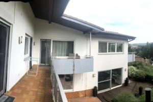 MörlenbachSchöne 128qm große Ferienwohnung in Waldrandlage的白色的房子,设有带阳台的甲板