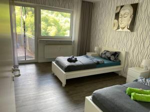 MörlenbachSchöne 128qm große Ferienwohnung in Waldrandlage的有两张床和一扇窗户的卧室