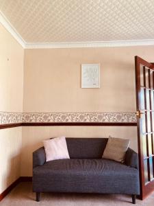 ein Sofa in einem Zimmer mit einer Wand in der Unterkunft 'Melrose' at stayBOOM in Lancaster