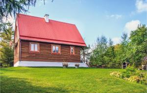 コセボにあるAwesome Home In Mragowo With 3 Bedroomsの緑の芝生に赤い屋根の木造家屋