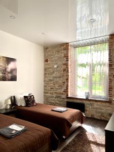 a bedroom with two beds and a brick wall at Vabriku 6 Apartment with sauna in Rakvere
