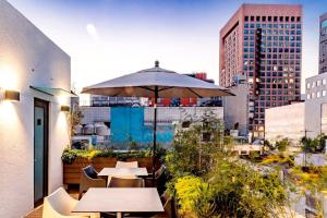 メキシコシティにあるROMÁNTICO Junto a Bellas Artes Centro Históricoの建物内のパティオ(テーブル、傘付)