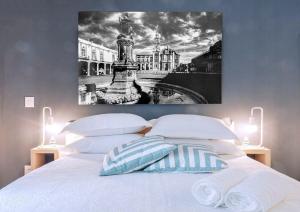 um quarto com uma cama branca e uma pintura na parede em ROMÁNTICO Junto a Bellas Artes Centro Histórico em Cidade do México