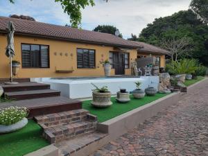 a house with a green lawn in front of it at Double Room - Robberg in Plettenberg Bay