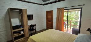 a bedroom with a bed and a desk and a window at Acogedora suite en Liguiqui - Manta 