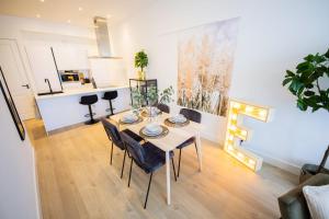 a dining room with a table and chairs and a kitchen at Earnestly 1 Bedroom Serviced Apartment 54m2 -NB306E- in Rotterdam