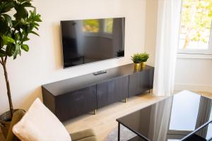 uma sala de estar com uma televisão de ecrã plano na parede em Earnestly 1 Bedroom Serviced Apartment 54m2 -NB306E- em Roterdã