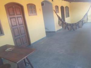 Pokój z drewnianym stołem i drzwiami w obiekcie Recanto Saqua w mieście Saquarema