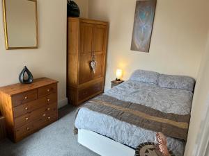 a bedroom with a bed and a wooden dresser at Oak Dene in Doncaster