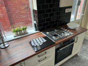 a kitchen with a stove and a counter top at Oak Dene in Doncaster