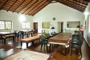 uma grande sala de jantar com mesas e cadeiras em The Nest bettathur, Coorg em Madikeri