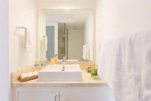 een witte badkamer met een wastafel en een spiegel bij Esquina mágica en el mejor edificio del Centro Histórico in Mexico-Stad +32 foto's