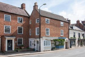 a row of brick buildings on a street at Cotswolds period townhouse near Stratford-upon-Avon, central location short walk to pubs, restaurants and shops in Shipston-on-Stour