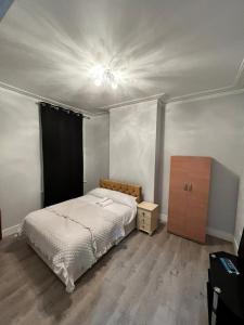 a bedroom with a bed and a dresser in it at Alfaomega in London
