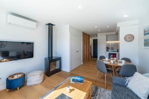 Riverside Lodge- 2 Bedroom Unit في Albert Town: غرفة معيشة مع طاولة ومدفأة