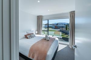 Riverside Lodge- 2 Bedroom Unit في Albert Town: غرفة نوم بها سرير ونافذة كبيرة