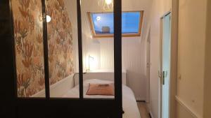Un espejo en una habitación con una cama y una ventana. en Villa Mignon grand studio vue Mer, en Mers-les-Bains
