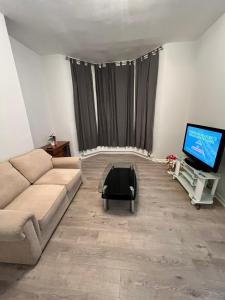 a living room with a couch and a television at Alfaomega in London