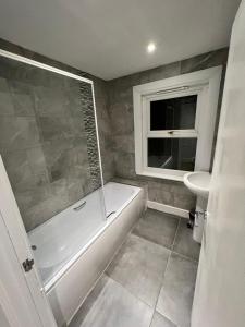 a bathroom with a shower and a tub and a sink at Alfaomega in London