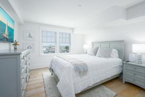 a white bedroom with a bed and a window at Thomas Sea Suites at Harbourtown in Plymouth