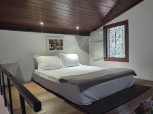 a bed in a bedroom with a wooden ceiling at Pousada Éden in Sao Jorge