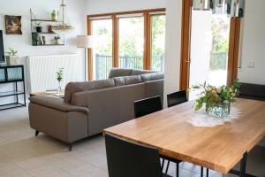 a living room with a couch and a wooden table at Ferienhaus Kaiserbaum in Illmitz