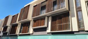 an external view of a building with wooden windows at Etna Suite Design Apartments in Catania