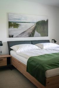 een slaapkamer met een bed met een schilderij aan de muur bij Ferienhaus Kaiserbaum in Illmitz
