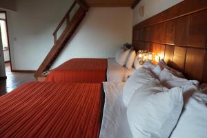 - une chambre avec 2 lits dotés de draps blancs et rouges dans l'établissement Torre del Conde, à Huasca de Ocampo