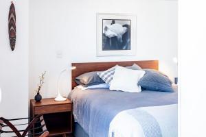 een slaapkamer met een bed en een tafel met een lamp bij SUPERMODERNO En Pleno Centro Histórico in Mexico-Stad +60 foto's