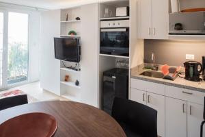 een keuken met een tafel, een wastafel en een tv bij SUPERMODERNO En Pleno Centro Histórico in Mexico-Stad