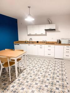 cocina con armarios blancos y mesa de madera en Apartament Ósemka en Mikołajki