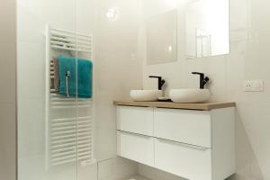 a white bathroom with two sinks and a mirror at Loft aux portes de Paris - Parking gratuit in Bagnolet +34 photos
