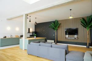 - un salon avec un canapé et une télévision murale dans l'établissement Loft aux portes de Paris - Parking gratuit, à Bagnolet
