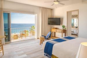 a hotel room with a bed and a large window at Mar del Cabo By Velas Resorts in San José del Cabo
