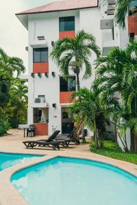 a hotel with a swimming pool in front of a building at Hotel Cañada Internacional in Palenque