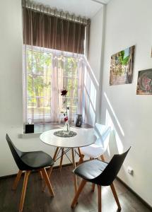 - une table et des chaises dans une chambre avec fenêtre dans l'établissement Vabriku 6 Apartment with sauna, à Rakvere