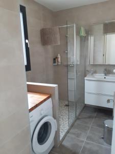 łazienka z pralką i umywalką w obiekcie Appartement fonctionnel proche du centre ville w mieście Narbona