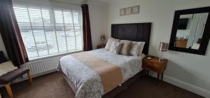 a bedroom with a bed and a large window at Tregarthen - Adult Only in Newquay