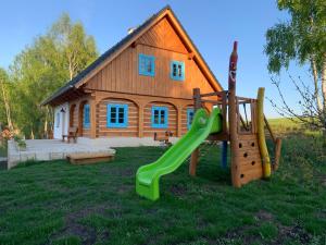 un parque infantil frente a una casa con tobogán en Roubenka Kokořínsko, en Dubá