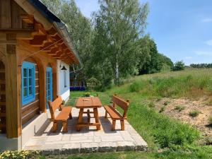 a picnic table and benches outside of a cabin at Roubenka Kokořínsko in Dubá