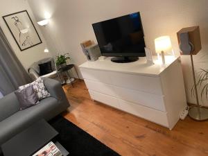 - un salon avec une télévision sur une commode blanche dans l'établissement NordiCasa, à Eger