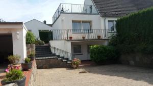 Casa blanca con escaleras y balcón en Cosy House en Scharbeutz