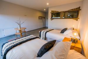 a room with three beds and a table and a table at Hotel Hacienda Dorotea in Puerto Natales