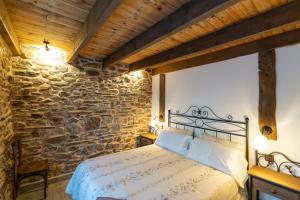 a bedroom with a bed in a stone wall at Las Morales Casa Rural 