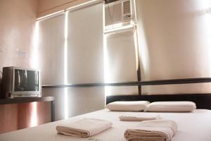 una stanza con un letto con asciugamani sopra di GV Hotel - Ormoc a Ormoc